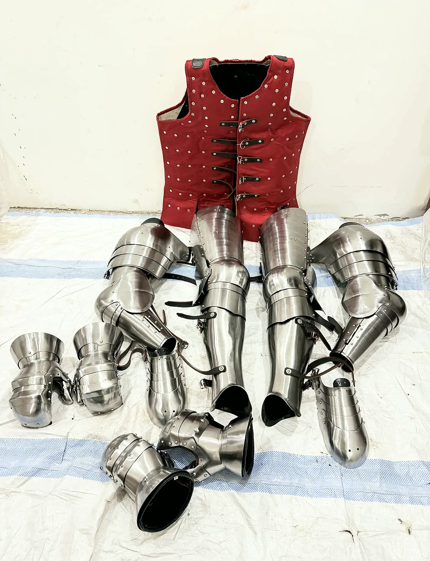 A complete buhurt kit — riveted brigandine, arms, legs and gauntlets laid out